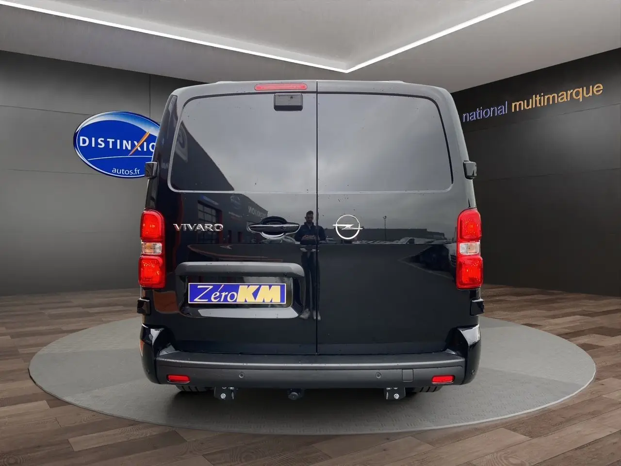 Vue arrière d'un Opel Vivaro noir avec attelage et feux arrière rouges dans un showroom.