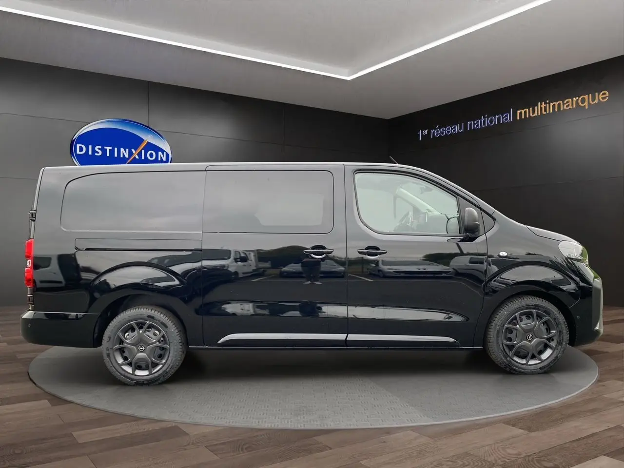 Profil latéral droit d'un Opel Vivaro noir 2025 avec portes coulissantes et jantes acier en showroom.