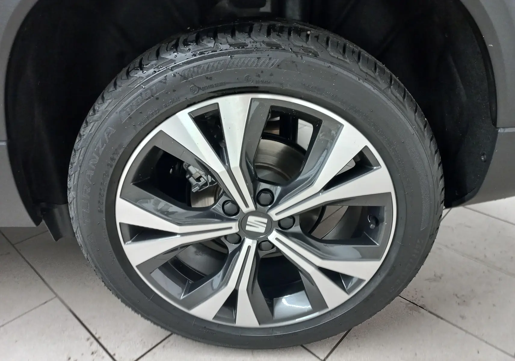 Gros plan sur la jante alliage 18'' usinée du SEAT Ateca 2.0 TDI noir Magic Nacré, vue côté roue avant.