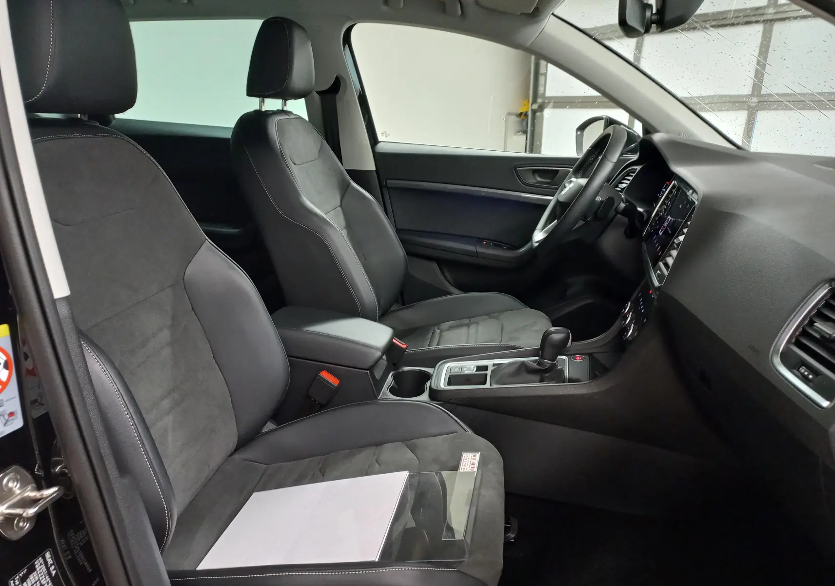 Vue intérieure côté conducteur du SEAT Ateca 2.0 TDI 150 DSG7 Copa, sièges noirs en cuir et alcantara, tableau de bord moderne.