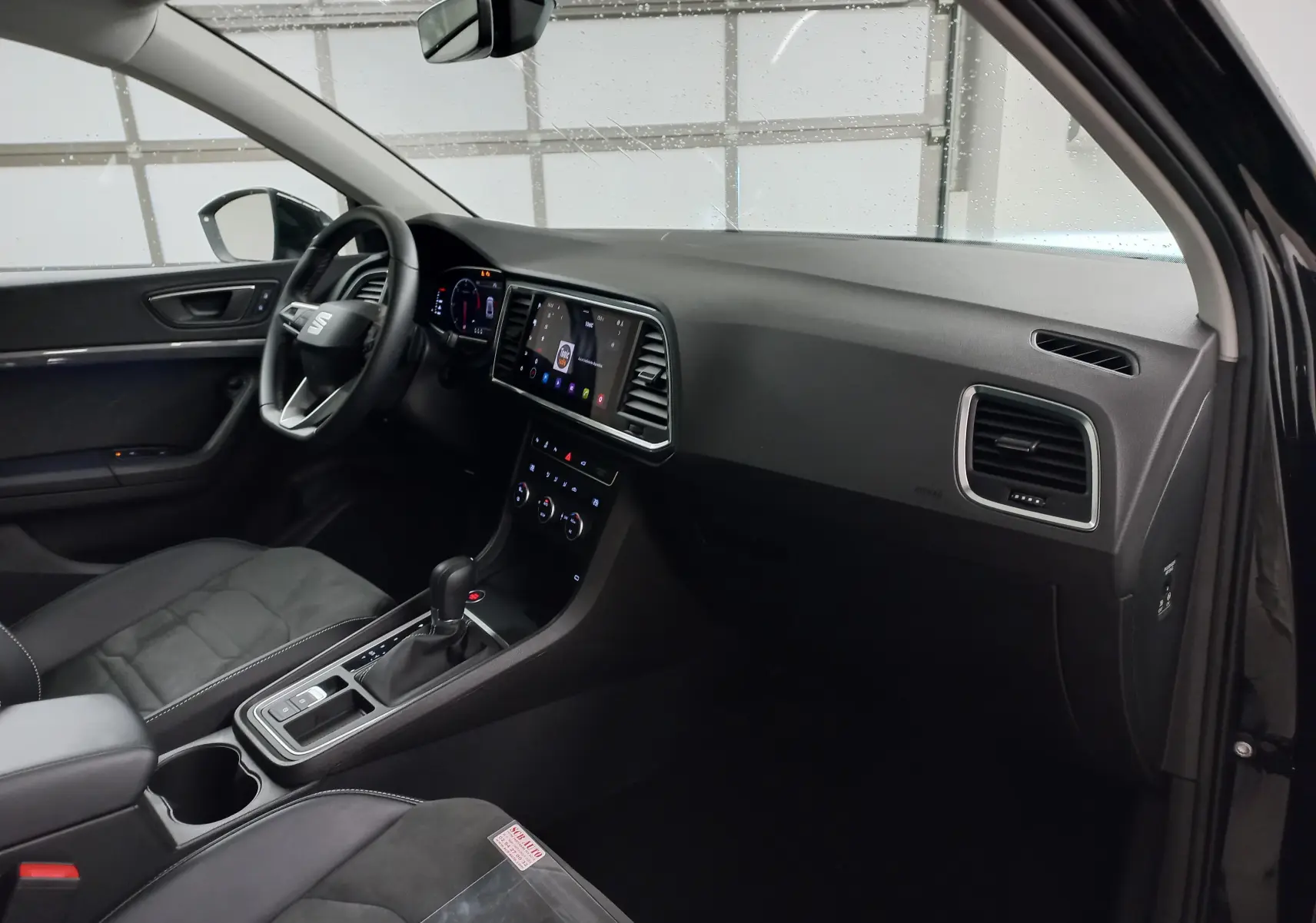 Intérieur côté conducteur du SEAT Ateca 2025 noir, tableau de bord moderne avec écran tactile et volant multifonction.