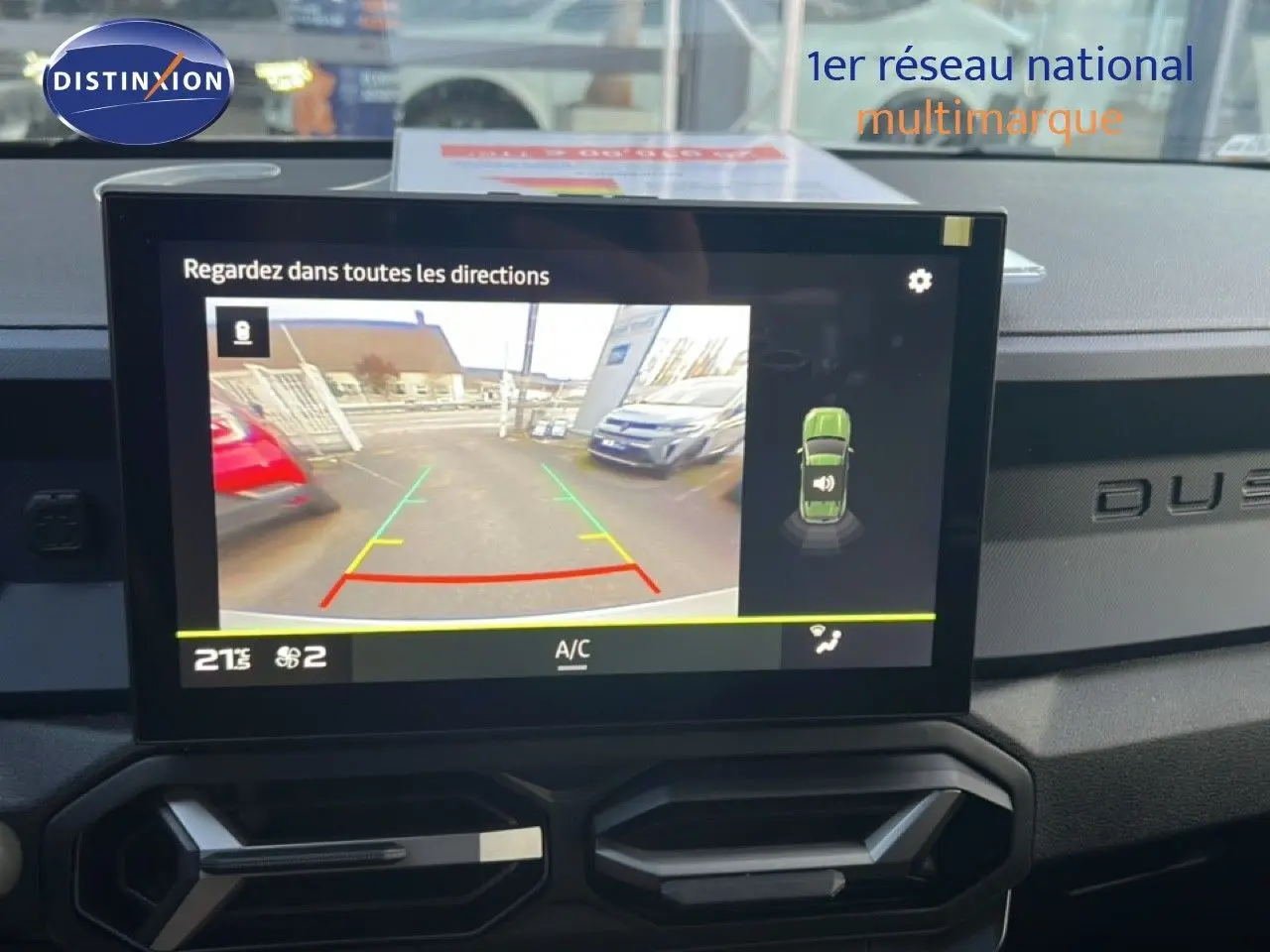 Écran central affichant la caméra de recul du Dacia Duster Hybrid 140 Journey, tableau de bord noir avec logo Duster visible.