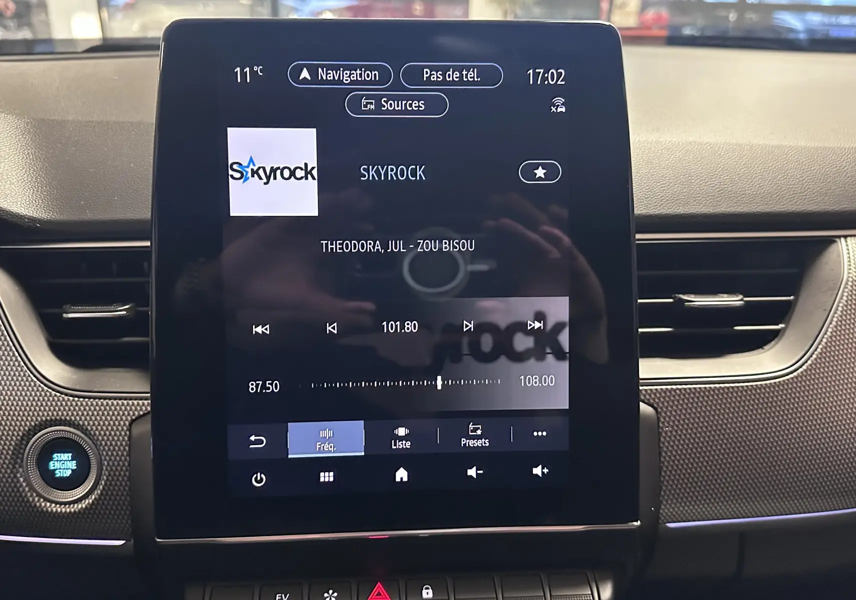 Écran central tactile du tableau de bord noir du Renault Arkana 1.6 E-Tech 145ch Intens, affichant la radio Skyrock.