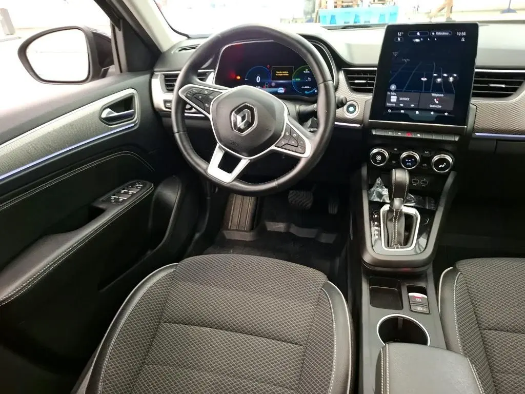 Intérieur noir du Renault Arkana 2022, vue du poste de conduite avec volant multifonction et écran tactile central.
