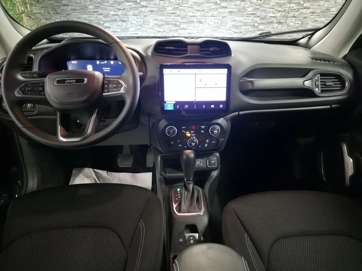 Vue frontale de l'intérieur du Jeep Renegade 2024 avec tableau de bord numérique et sellerie noire.