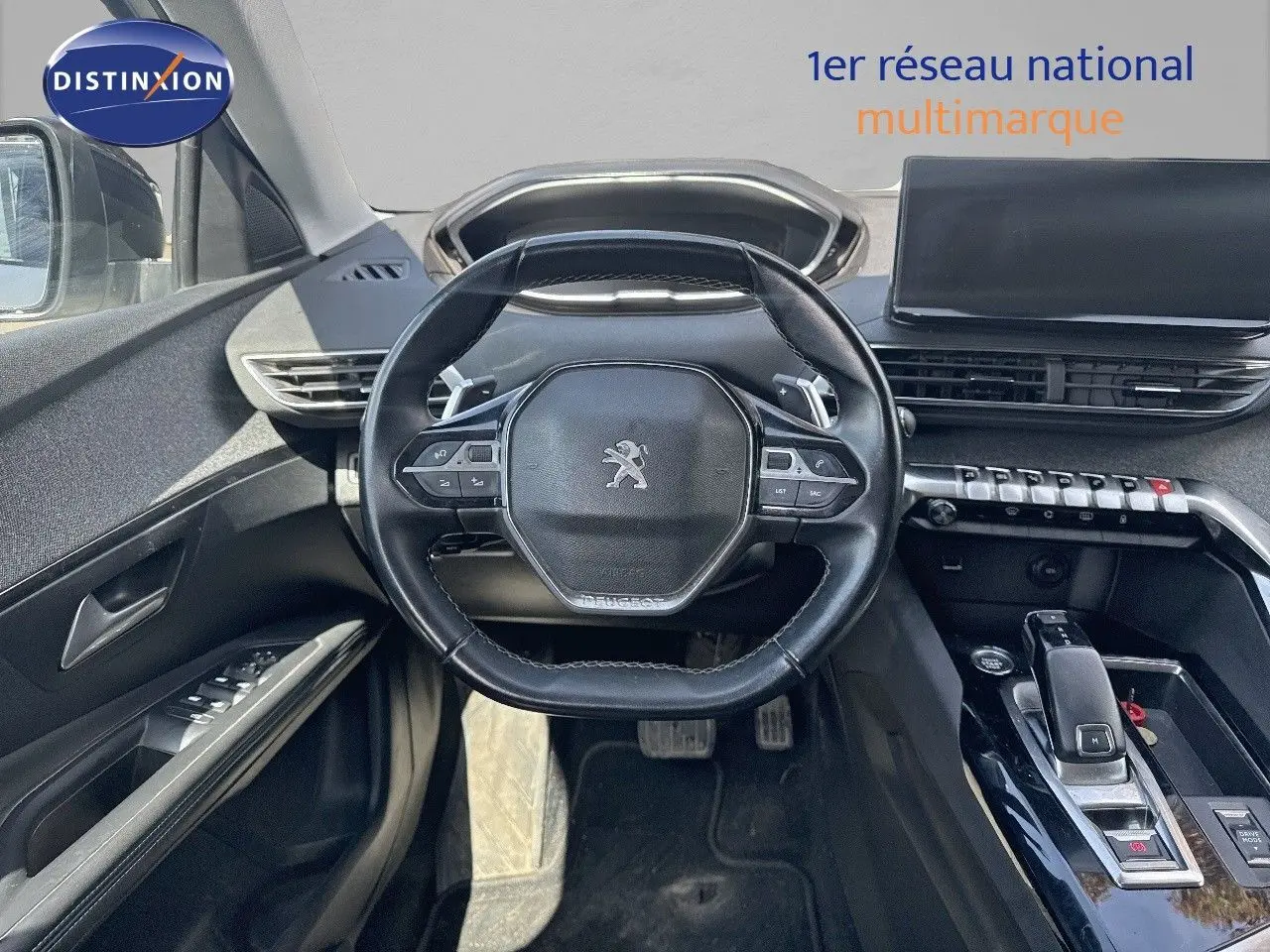 Vue intérieure centrée sur le volant compact et la console centrale noire du Peugeot 3008 blanc nacré 2022.