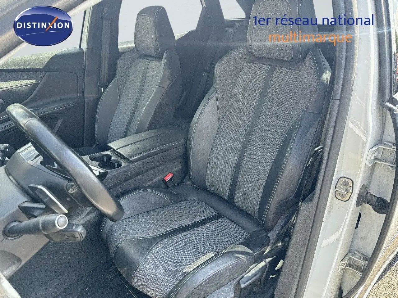 Vue intérieure côté conducteur du Peugeot 3008 blanc nacré, mettant en valeur le siège avant en tissu et cuir noir.