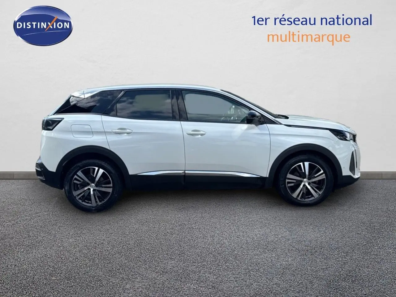 Vue de profil côté gauche du Peugeot 3008 blanc nacré métal de 2022 avec jantes bi-ton et vitres teintées.