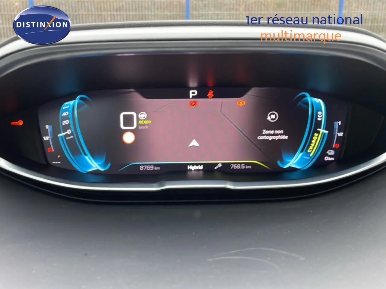 Tableau de bord numérique du Peugeot 3008 hybride 2024 affichant vitesse, autonomie et indicateurs en vue frontale.