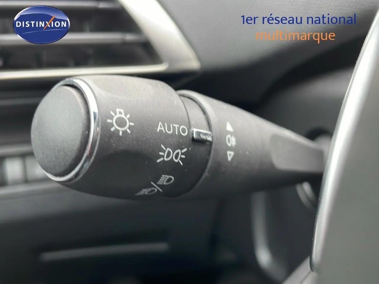 Gros plan sur la commande des feux du Peugeot 3008 gris Artense, intérieur noir, version hybride rechargeable 2024.