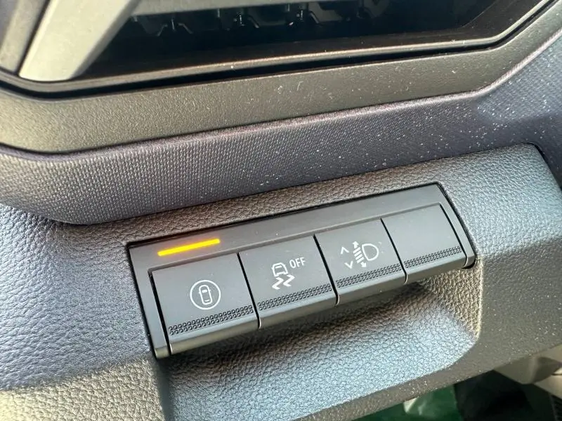 Gros plan sur les boutons de commande du tableau de bord du Dacia Duster 2026, intérieur noir texturé.