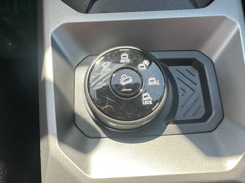 Gros plan sur la molette de sélection des modes de conduite du Dacia Duster 1.2 hybrid-G, finition Expression, intérieur gris.