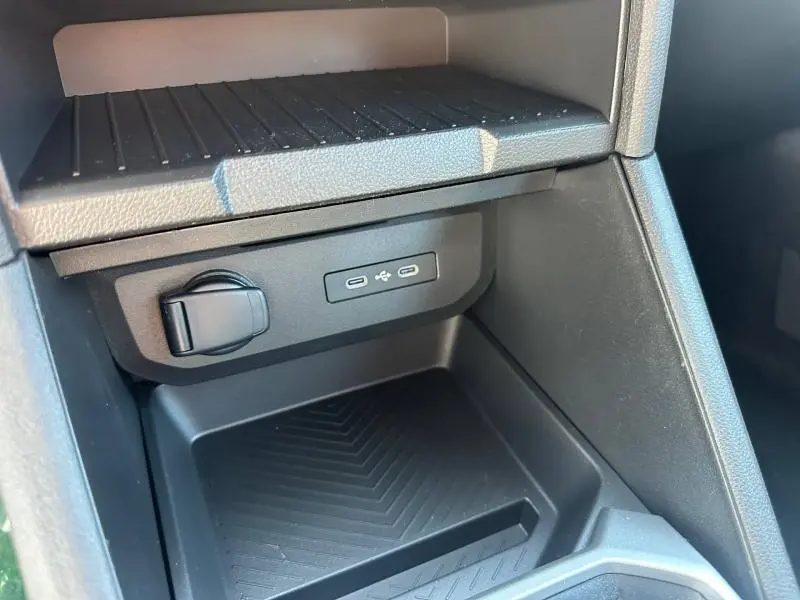 Gros plan sur la console centrale noire du Dacia Duster 2026 montrant prises USB-C et prise 12V.