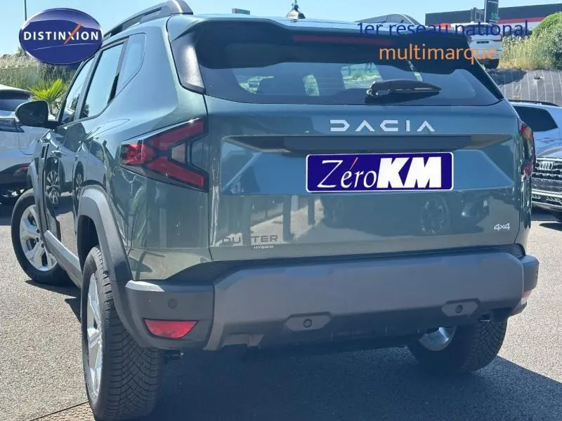 Vue 3/4 arrière d'un Dacia Duster 1.2 hybrid-G 150ch vert cèdre métallisé avec logo DACIA et badge 4x4 visible.