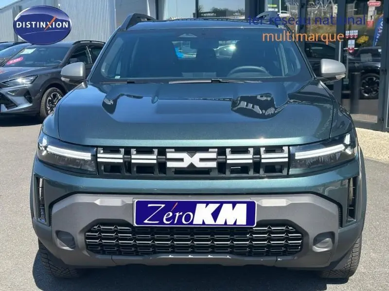 Vue avant d'un Dacia Duster 2026 Vert Cèdre métallisé avec calandre noire et phares LED fins.
