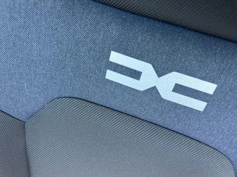 Détail du tissu bleu denim avec logo Dacia réfléchissant sur le siège intérieur du Dacia Duster 2026.
