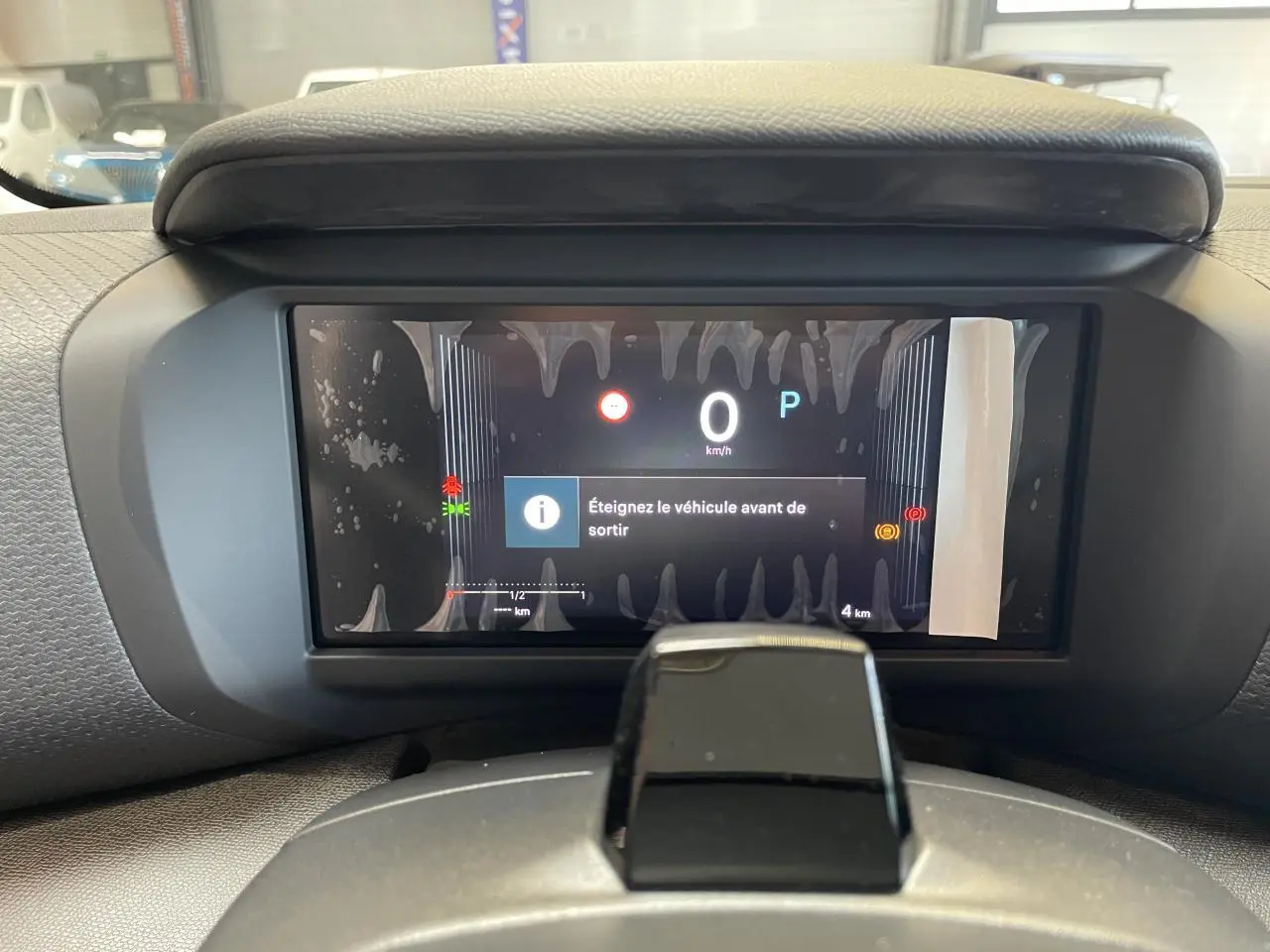 Vue rapprochée du tableau de bord numérique de la Citroën C4 blanche, affichant un message d'arrêt du véhicule.