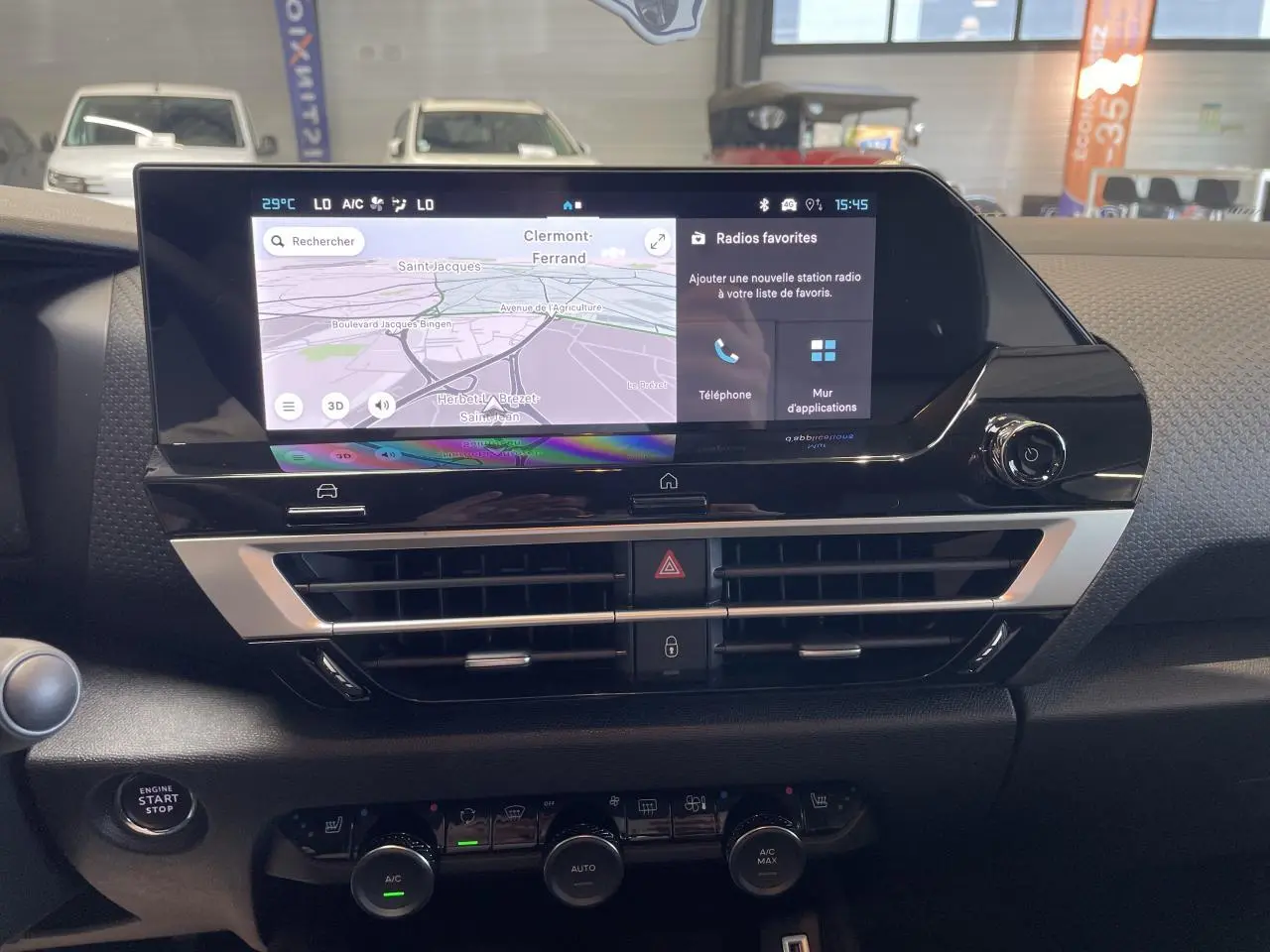 Vue intérieure du tableau de bord de la Citroën C4 blanche, écran tactile central avec navigation et commandes climatisation.
