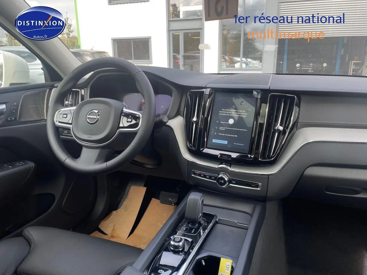 Intérieur avant du Volvo XC60 gris 2024, vue côté conducteur sur tableau de bord et console centrale moderne.