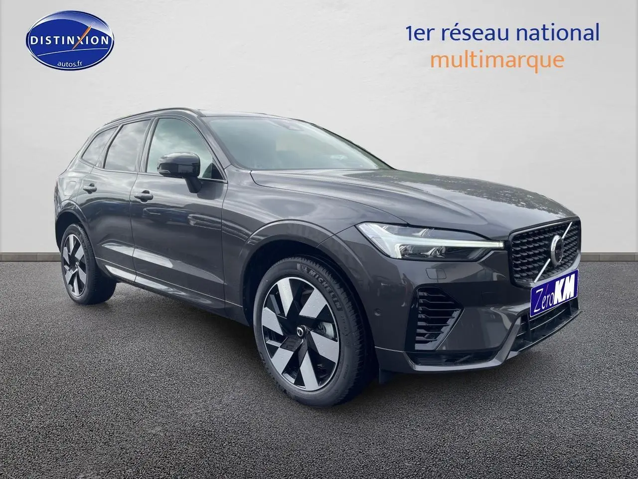 Vue 3/4 avant d'un Volvo XC60 gris brume métallisé avec calandre noire et jantes alu distinctives.