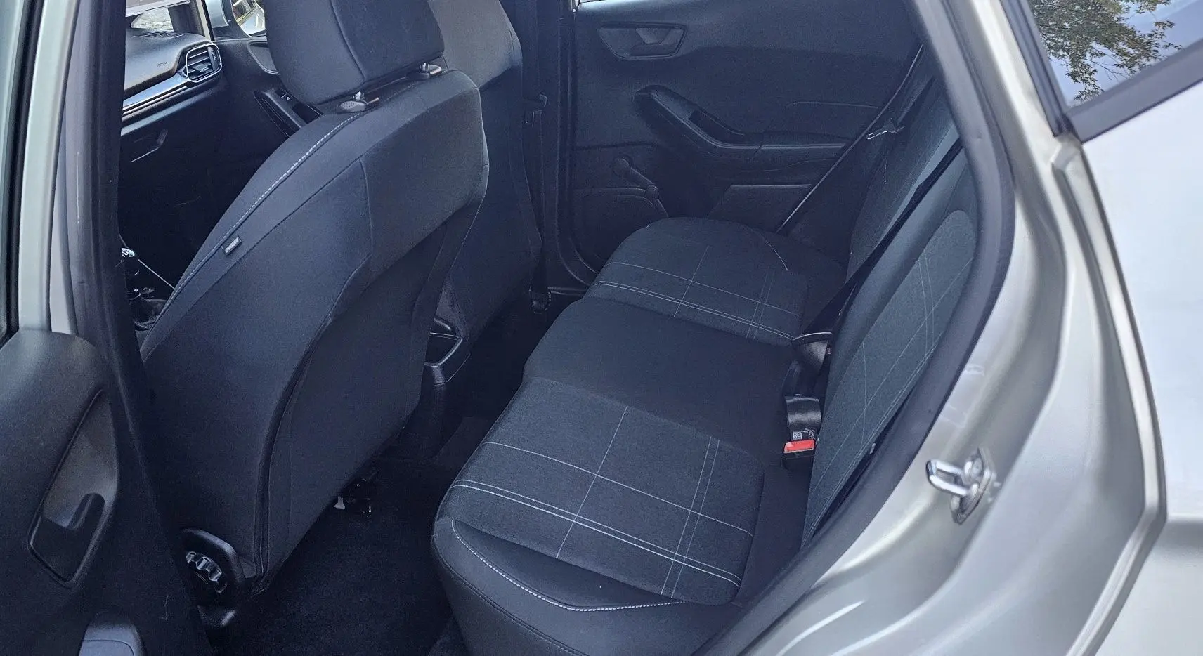 Vue intérieure arrière côté droit d'une Ford Fiesta 2021 gris lunaire, sièges tissu noir à motifs gris clair.