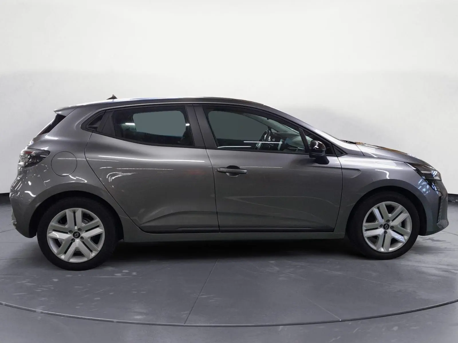 Profil côté droit de la Renault Clio V E-Tech Full Hybrid 145 gris schiste, avec jantes alliage et lignes fluides.