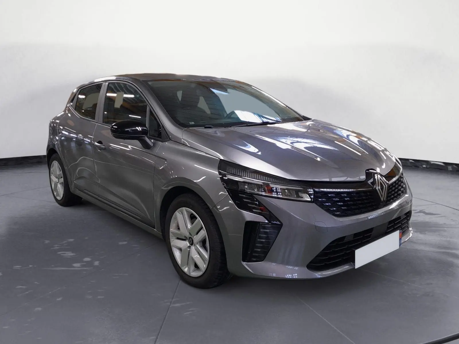 Renault Clio V E-Tech gris schiste vue 3/4 avant avec projecteurs LED et jantes alliage modernes.