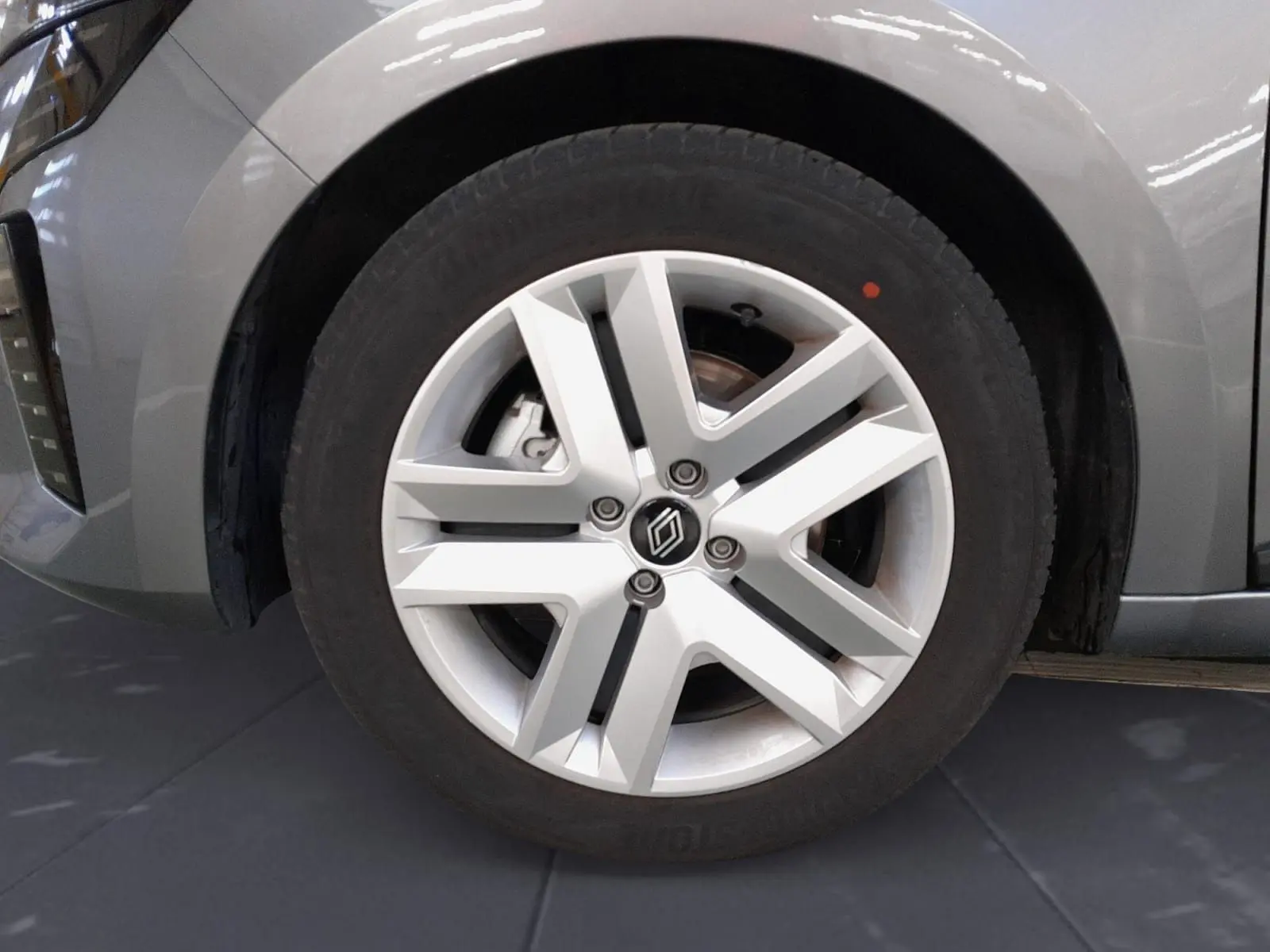 Gros plan sur la roue avant droite de la Renault Clio V gris schiste, avec jante alliage au design moderne.