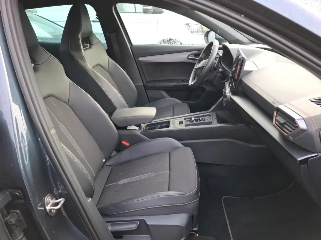 Vue intérieure côté gauche de la CUPRA Formentor gris, montrant sièges baquets noirs et tableau de bord avec inserts copper.