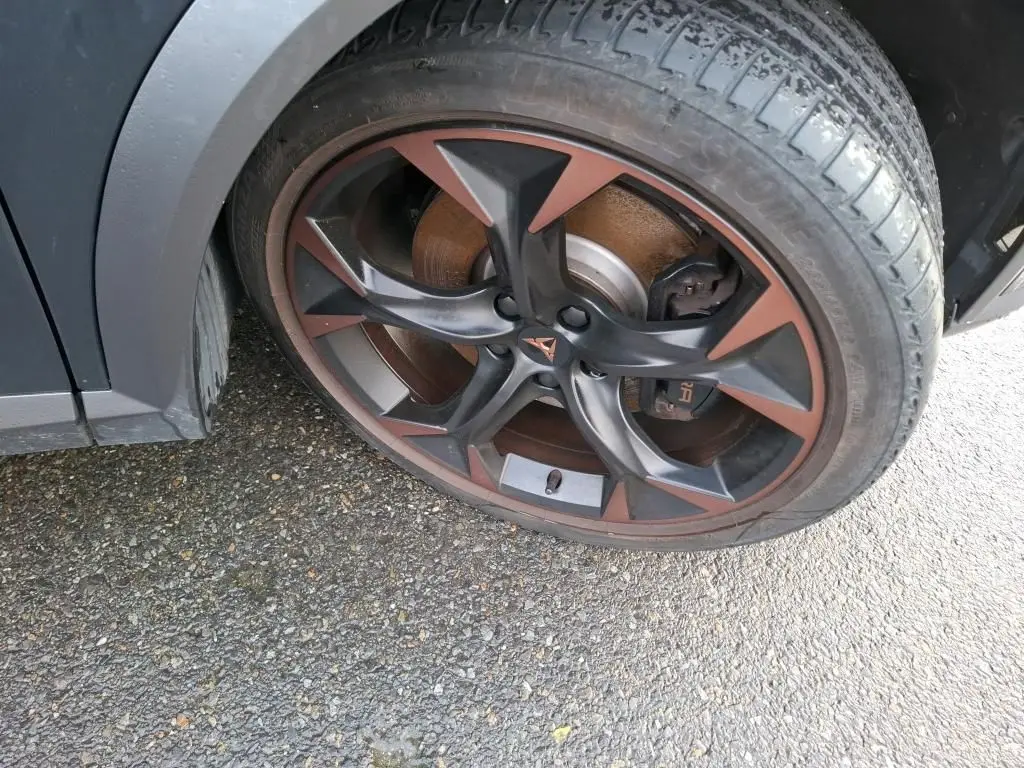 Gros plan sur la jante alliage 19 pouces bicolore noir et cuivre du côté avant droit du CUPRA Formentor gris.