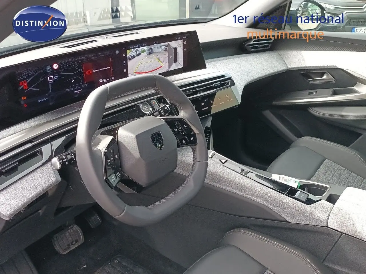 Intérieur du Peugeot 5008 2025 en gris titane, vue côté conducteur sur le volant et l’écran numérique large.