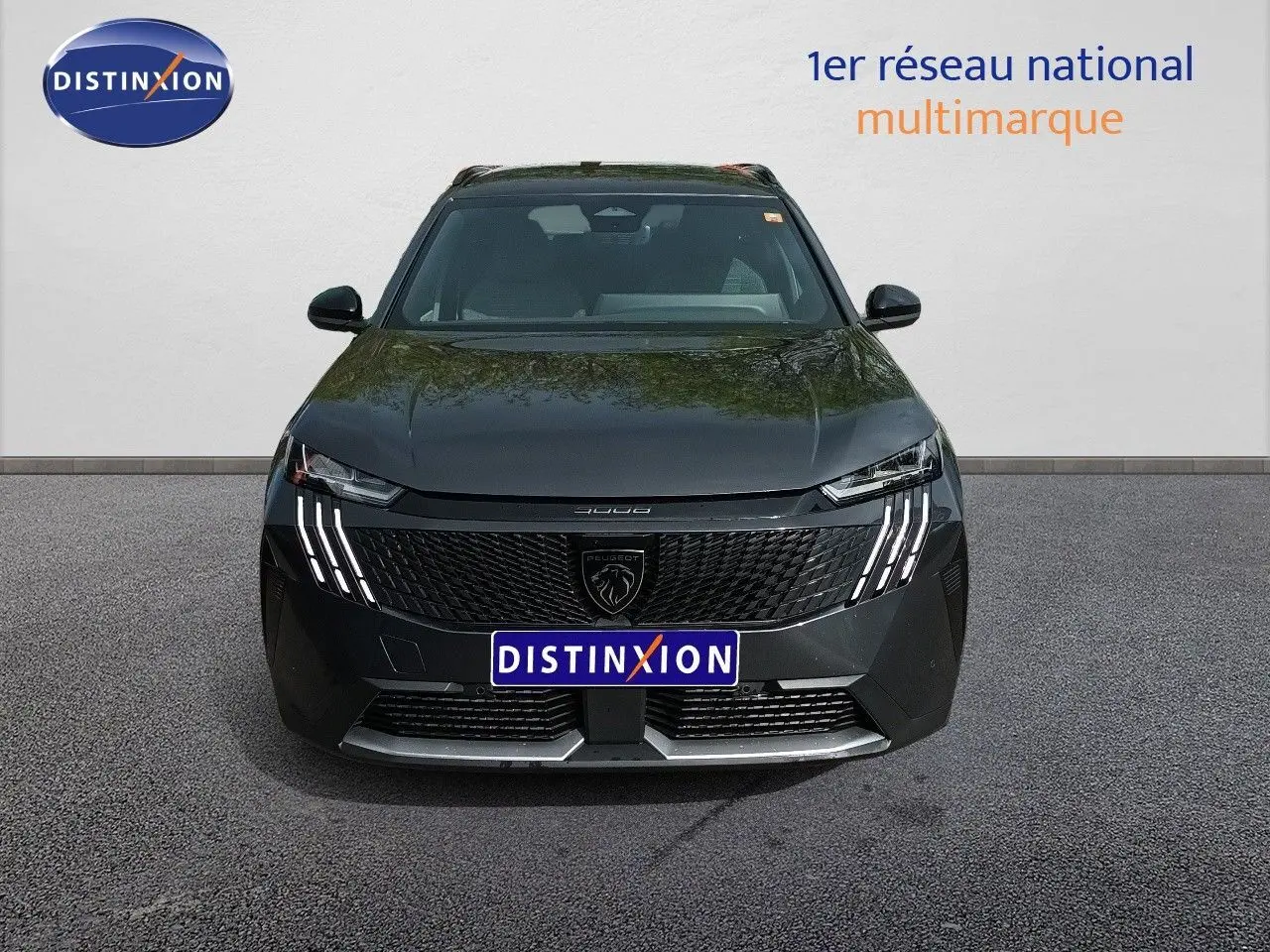 Vue avant d’un Peugeot 5008 gris titane métal avec calandre noire et feux LED distinctifs en griffes.