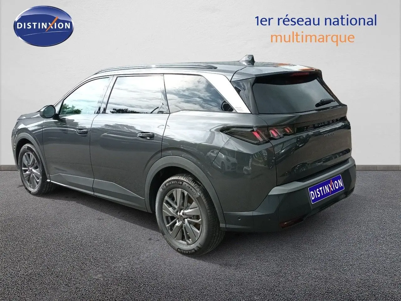 Peugeot 5008 gris titane métal en 3/4 arrière droit, SUV hybride avec jantes alliage et vitres teintées.
