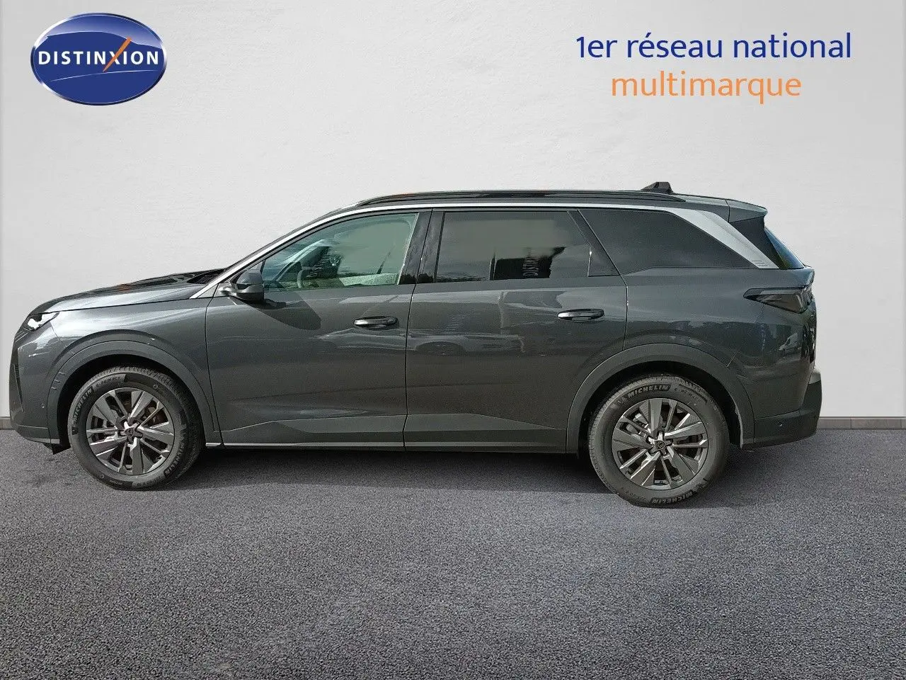 Peugeot 5008 gris titane métal vue de profil côté gauche, SUV hybride 2025 avec jantes alliage et toit panoramique.