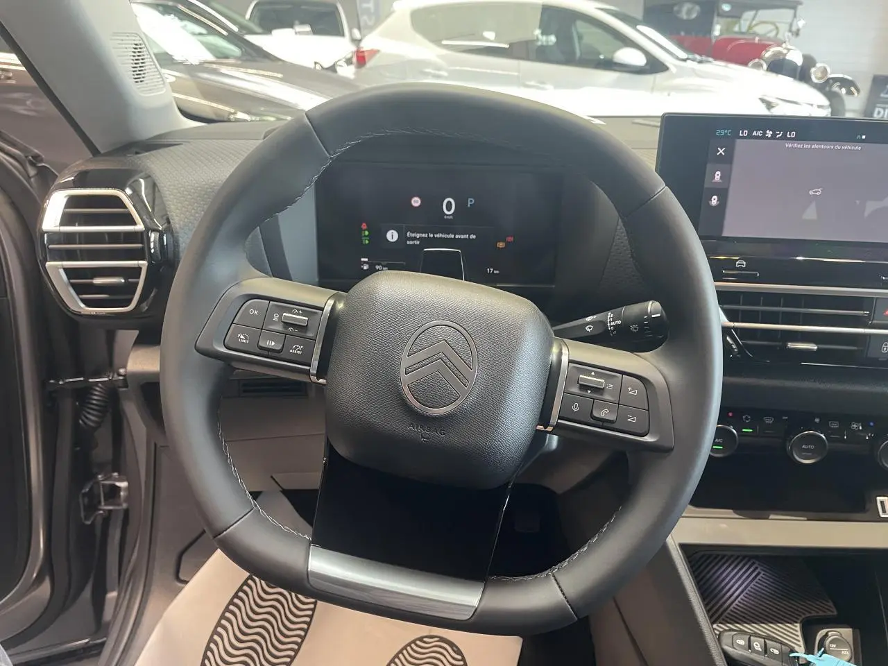 Vue rapprochée du volant cuir noir de la Citroën C4 2026 avec tableau de bord numérique et écran tactile central.