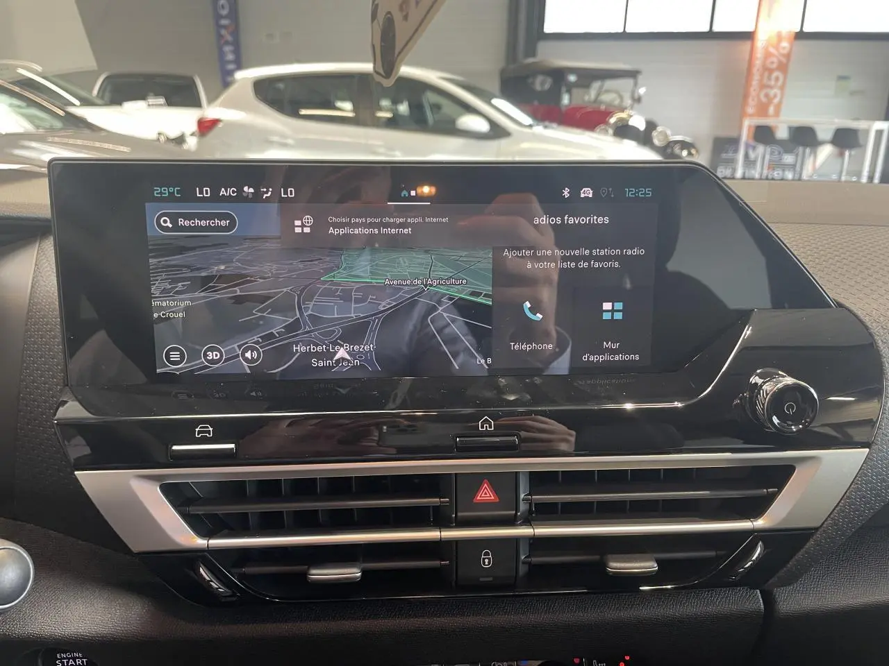 Vue rapprochée de l'écran tactile central et des aérateurs du tableau de bord de la Citroën C4 hybride gris intérieur.
