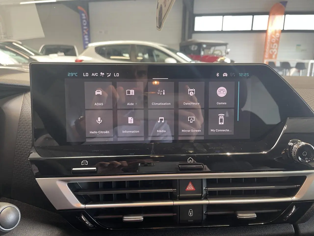 Écran tactile central et aérateurs du tableau de bord de la Citroën C4 gris, vue intérieure frontale.