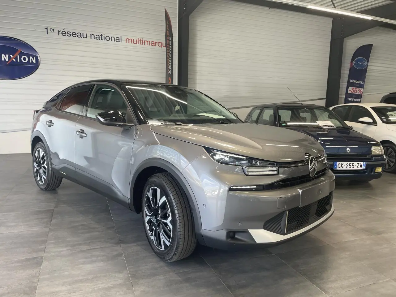 Citroën C4 gris métallisé en 3/4 avant droit avec toit noir Perla Nera et jantes alliage 18 pouces.