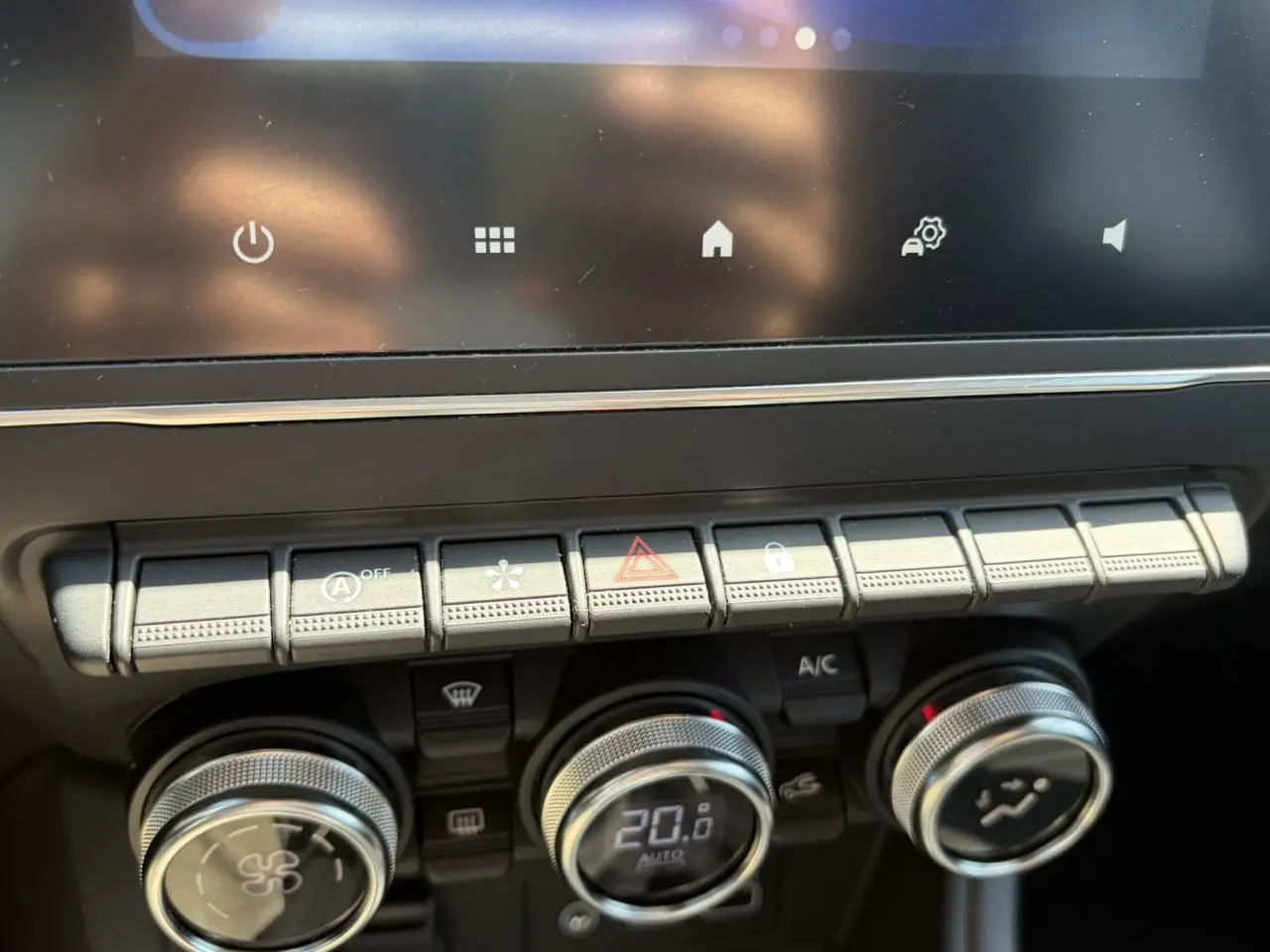 Gros plan sur la console centrale du Renault Captur 2024, montrant les commandes de climatisation et les boutons de fonction.