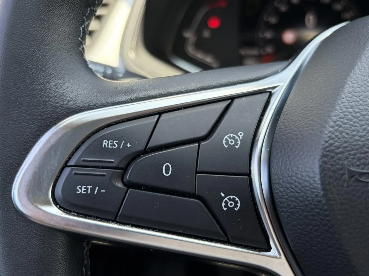 Gros plan sur les commandes de régulateur de vitesse au volant du Renault Captur TCE 90 Techno 2024.