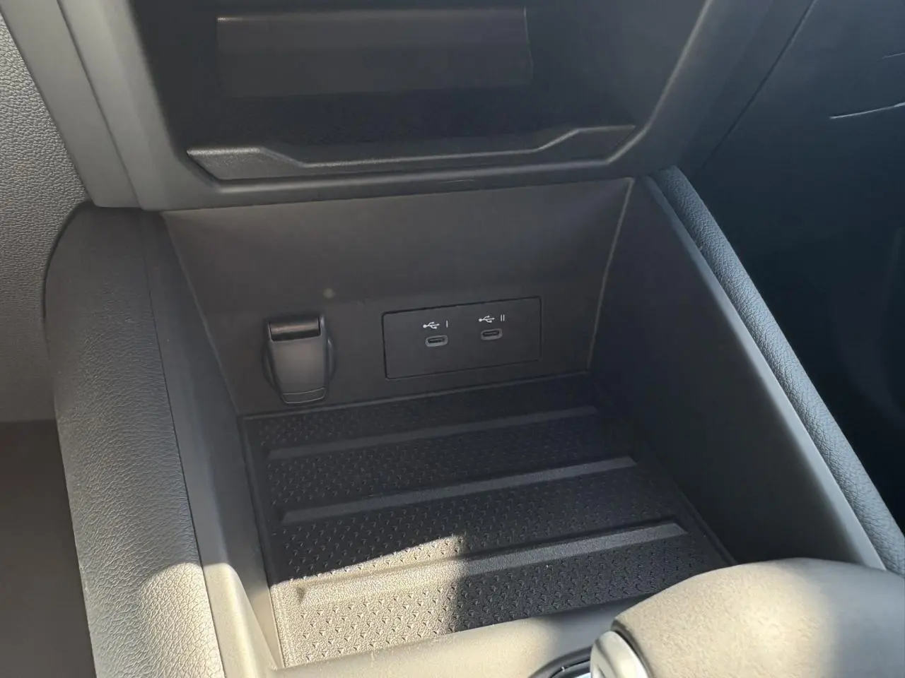 Gros plan sur la console centrale du Renault Symbioz gris, montrant les ports USB-C et une prise 12V intégrés.