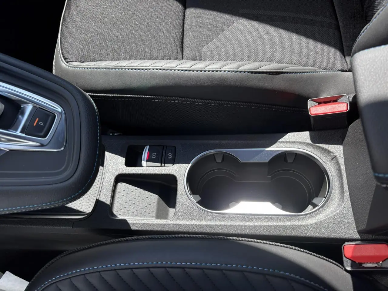 Gros plan sur la console centrale noire avec surpiqûres bleues et porte-gobelets du Renault SYMBIOZ Gris Rafale.