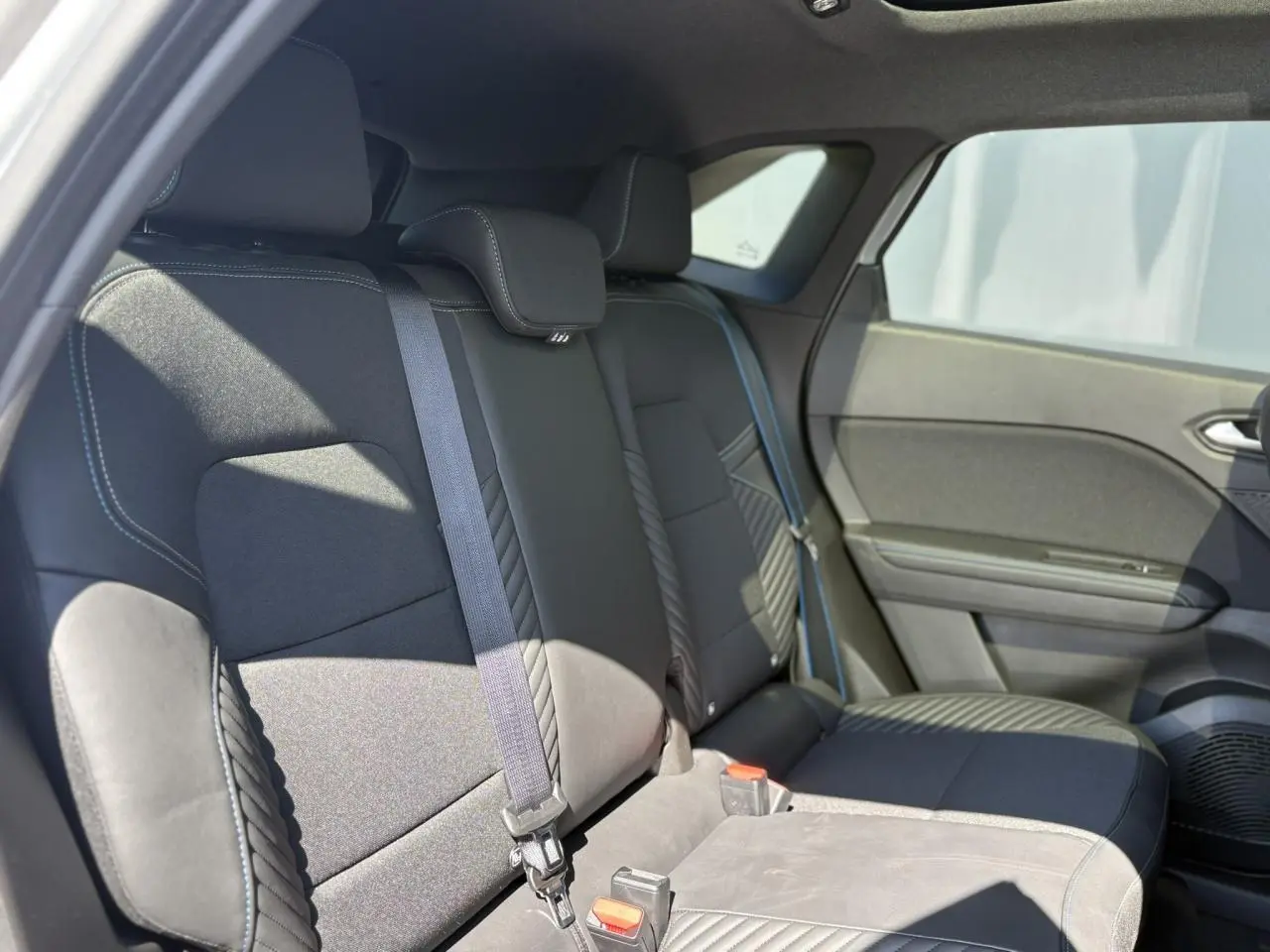Vue intérieure côté droit sur la banquette arrière noire du Renault SYMBIOZ 2025, avec ceintures de sécurité visibles.