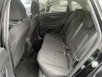 Vue intérieure arrière de la Hyundai i20 2025 noire Phantom Metal, montrant les sièges arrière en tissu et les ceintures de sécurité.