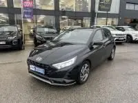 Vue 3/4 avant d’une Hyundai i20 2025 noir Phantom Metal avec phares LED et jantes alliage visibles sur parking extérieur.