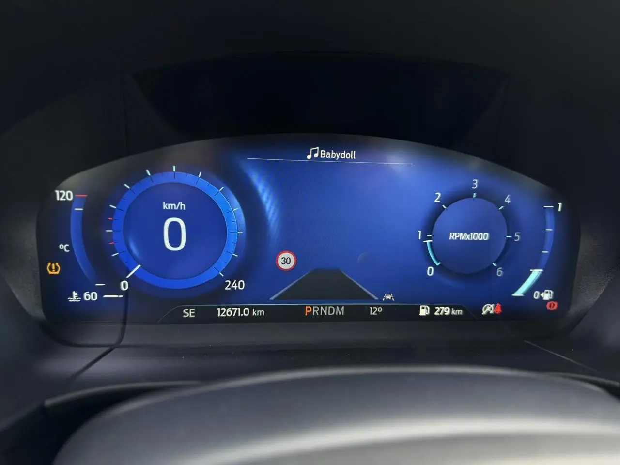 Vue rapprochée du combiné d'instrumentation numérique bleu du Ford Kuga 2023, affichant vitesse, régime et alertes.