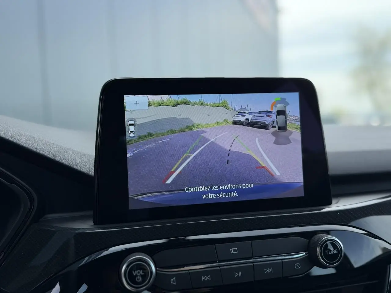 Écran central du Ford Kuga noir affichant la caméra de recul avec guidage de trajectoire en extérieur.