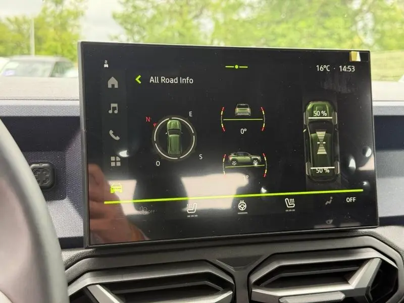 Écran tactile du tableau de bord du Dacia Duster 1.2 hybrid-G 150ch, affichant infos tout-terrain et température extérieure.