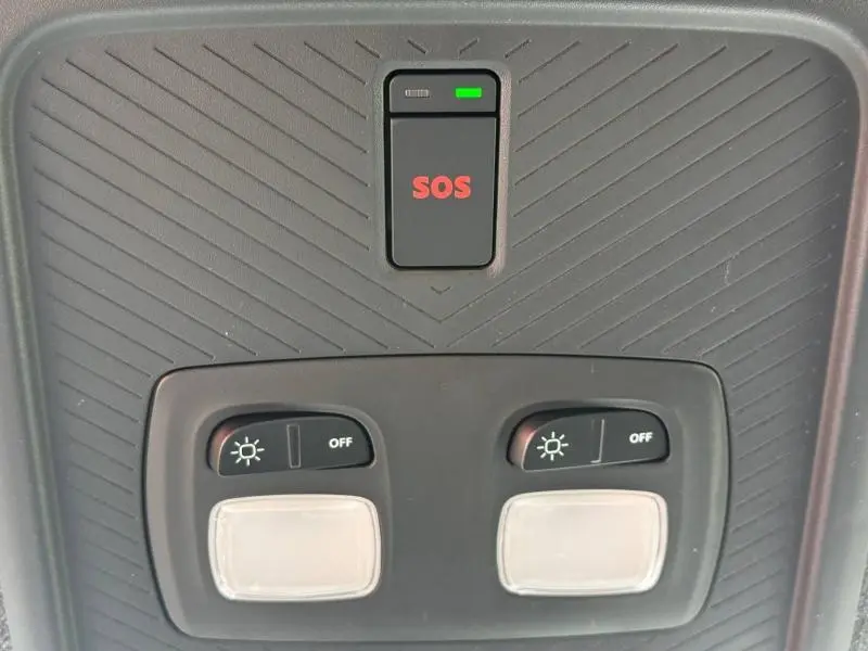 Gros plan sur la console de plafond gris avec bouton SOS rouge et commandes d’éclairage intérieur du Dacia Duster 2026.