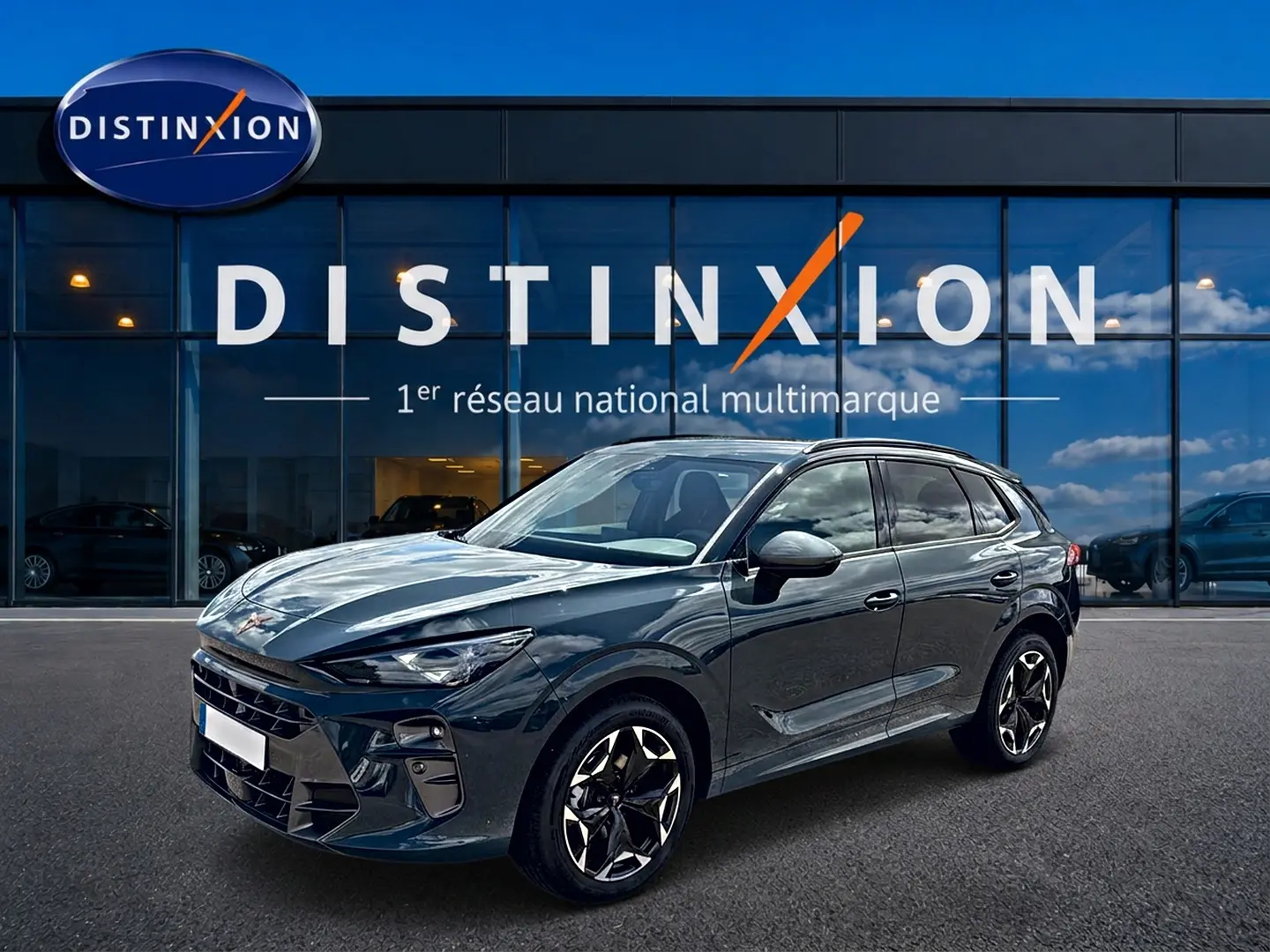Vue 3/4 avant droite d'une CUPRA Terramar 2026 bleu fjord avec jantes 19 pouces devant une vitrine Distinxion.